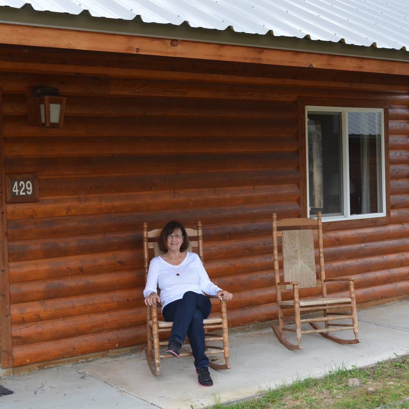 Nana sitting in a rocking chair outside a cabin