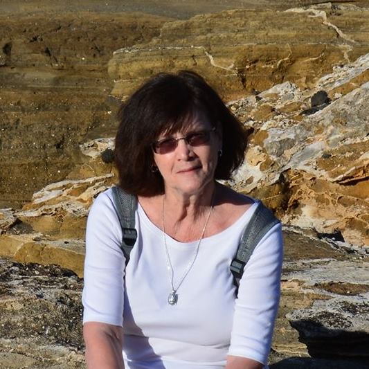 Portrait of Nana seated outdoors among rocky scenery