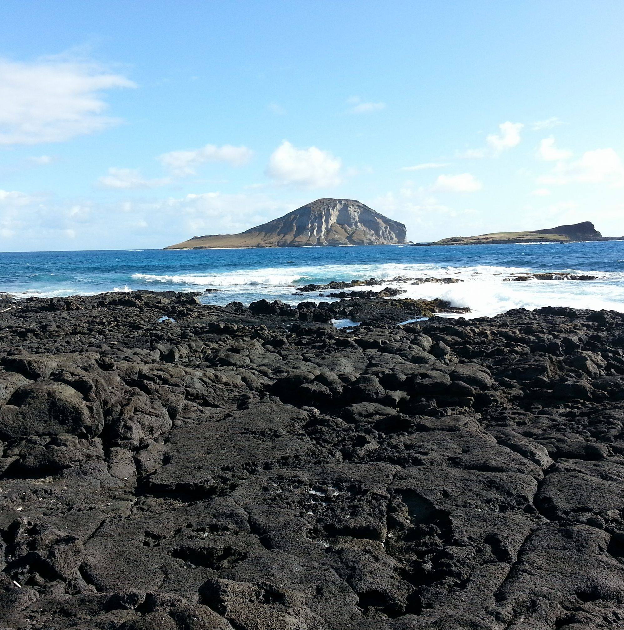 Ocean view with rocky shore and an island in the distance